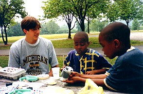 photo of volunteer and kids doing an experiment
